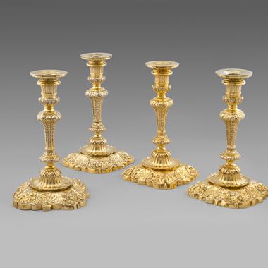 An Important Set of Four Silver-Gilt Royal Candlesticks