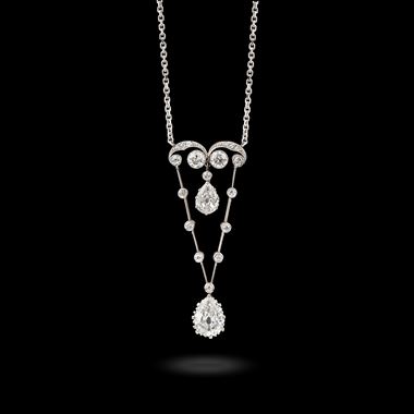 An early 20th century scroll and pear shaped diamond pendant