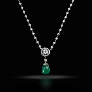 An emerald and diamond pendant on a diamond set chain, circa 1910