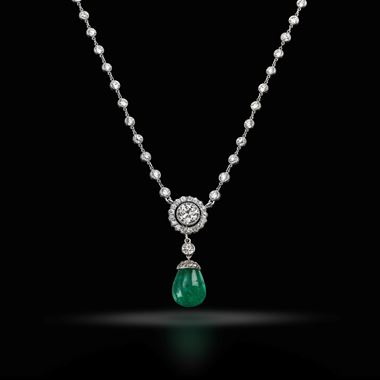 An emerald and diamond pendant on a diamond set chain, circa 1910