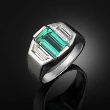 An emerald and diamond ring set in a platinum mount