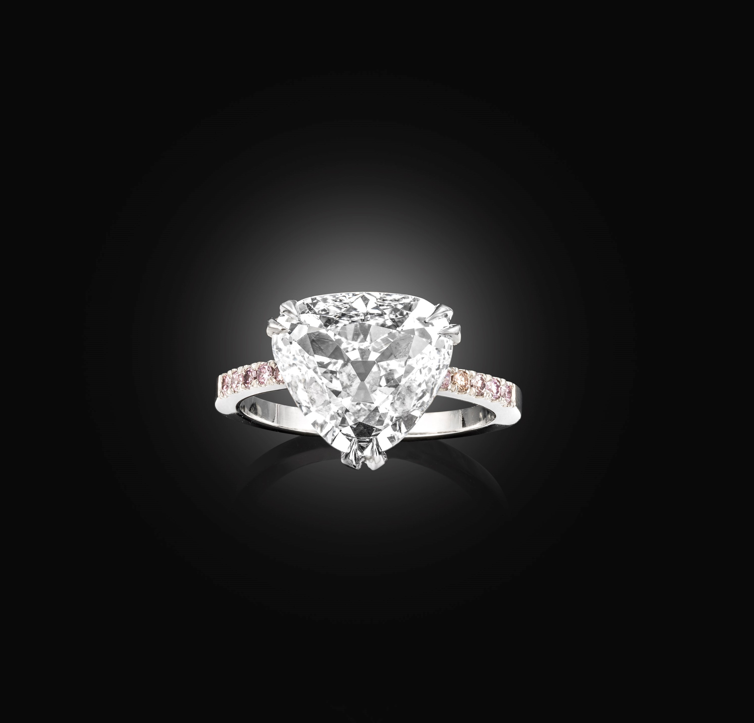 A pear shaped diamond ring with a pink diamond and platinum setting