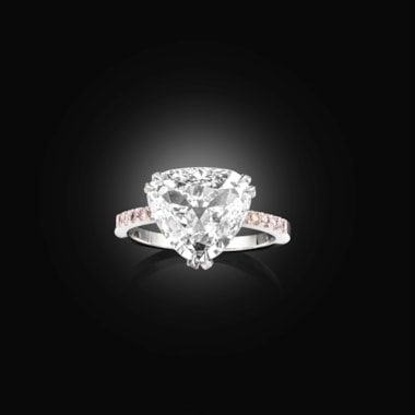 A pear shaped diamond ring with a pink diamond and platinum setting