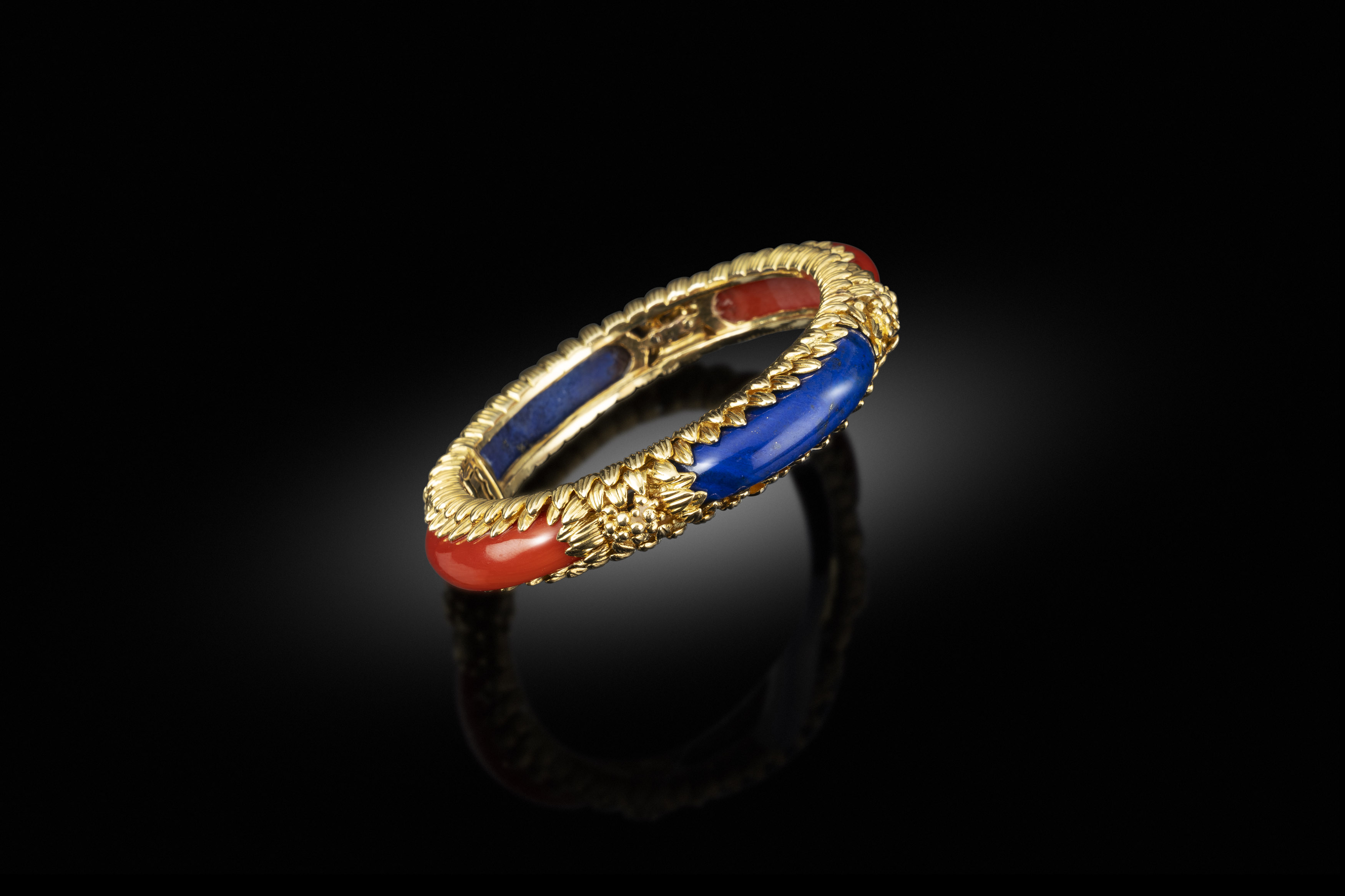 A 1980s gold, coral and lapis bangle