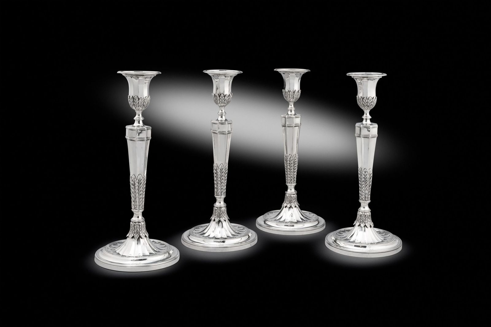 A Set of four George III Cast Candlesticks